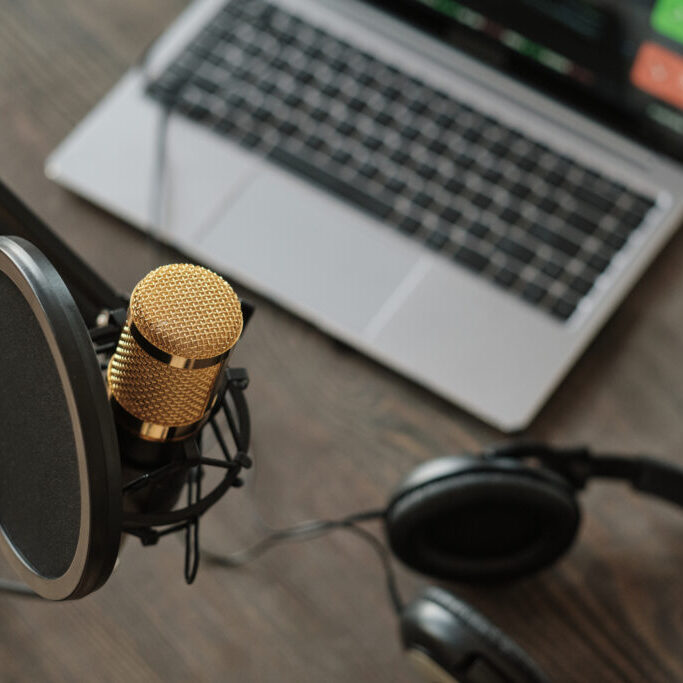 Close-up of microphone and laptop with headphones on the table in recording studio